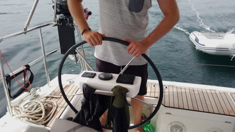 Medium-shot-of-male-on-rowing-wheel-at-sailboat
