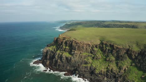 Aerial-panorama-of-rocky-coastline-with-green-meadows,-Indian-Ocean