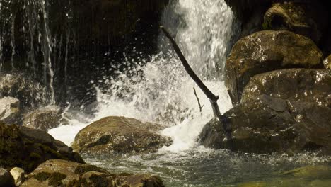 Water-cascading-down-rocks-in-a-mountain-stream,-close-up