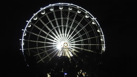 Night-view-of-amusement-park-at-night-,-big-Ferris-wheel-with-festive-blue-illumination-against-night-sky-,famous-tourist-attraction,-Agadir-city-in-Morocco