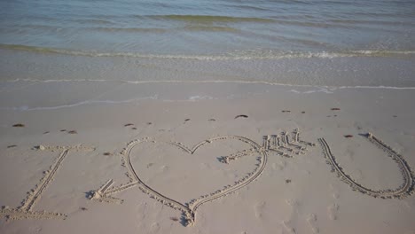 Static-shot-of-I-Love-You-inscribed-in-the-sand-on-a-beach