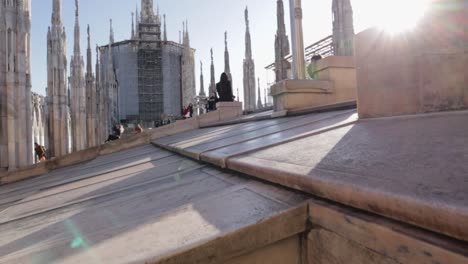 Rooftop-of-the-Duomo-cathedral-in-Milan-Italy-during-the-morning-with-few-people-and-bright-sunny-day,-pedestal-up