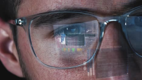 Programmer-Hacker-works-on-computer-screen---Code-is-reflected-in-his-eyes-and-on-the-glasses---Close-up