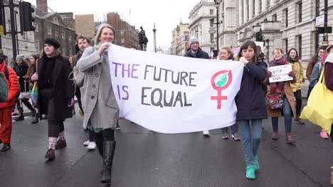 A-woman-and-a-young-girl-hold-a-banner-that-says,-“The-future-is-equal”-on-the-March-For-Women-in-London-on-International-Women’s-Day