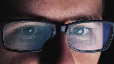Man-works-on-computer-screen,-which-is-reflected-on-his-glasses---code,-numbers,-network---Close-up