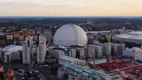 Revealing-pull-back-drone-shot-of-Ericsson-Globe-area-late-afternoon