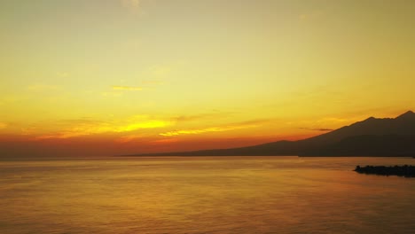 Aerial-panning-view-of-a-golden-sunset-in-the-popular-holiday-location-of-Indonesia
