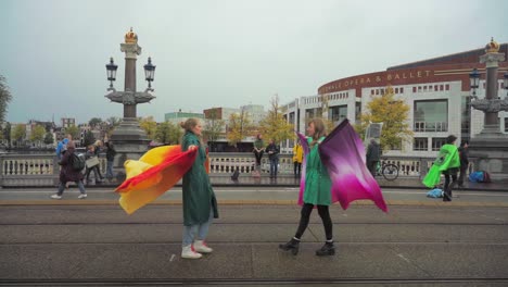 Young-female-student-Street-artists-show-performance-art-with-wings-walking-towards-eachother-at-an-extinction-rebellion-climate-protest-in-Amsterdam