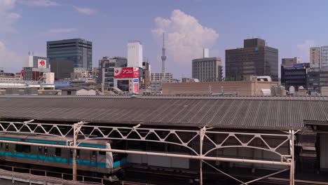 Typische-Sommerwolken-Hinter-Tokyo-Skystree-Mit-Wartendem-Zug-Im-Bahnhof-In-Der-Nähe-Von-Ueno