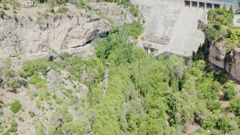 Aerial-tilt-up-shot-of-the-Pantano-de-Entrepenas-mountains,-lake-and-a-dam