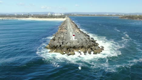 Flying-around-the-very-tip-of-the-Gold-Coast-seaway-with-small-waves-crashing-on-the-rocks
