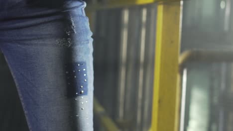 Nahaufnahme-Der-Hände-Eines-Arbeiters,-Die-Jeansfaden-Verziehen