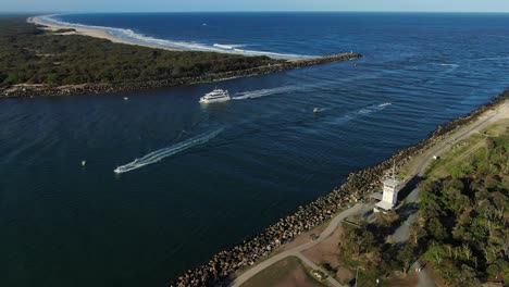 Cruise-boat-entering-Gold-Coast-seaway-between-South-Stradbroke-island-and-Gold-Coast-spit,-at-sunset