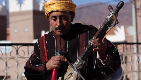 Medium-shot-of-berber-musician-playing-bowed-instrument-rabab-and-singing-traditional-songs-in-Tafraoute,-Morocco
