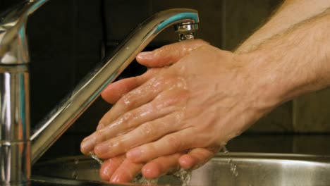 Washing-hands-and-rinsing-with-water-in-a-home-kitchen-sink-Slow-motion