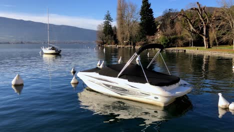 A-Larson-boat-in-the-water,-covered-and-rocking-in-the-small-waves-of-Lake-Leman