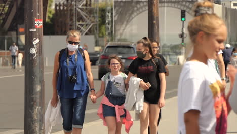 Slow-motion,-European-mother-and-daughters-with-protective-masks-on-their-faces-against-coronavirus-making-tourism-in-Paris-during-the-summer-of-2020