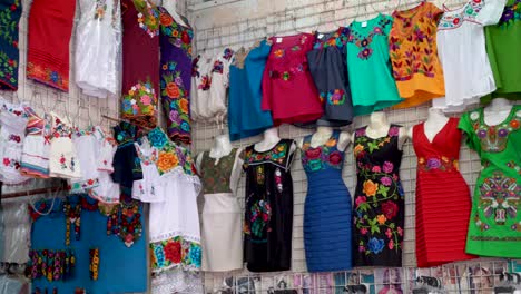 Camera-panning-left-showing-colorful-designer-huipil-blouses-indigenous-to-Merida,-Yucatan,-Mexico