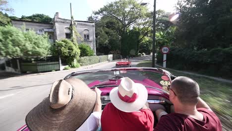 Amigos-En-Un-Viejo-Coche-Clásico-Tradicional-Cabrio-Conduciendo-Por-Una-Carretera-De-La-Habana
