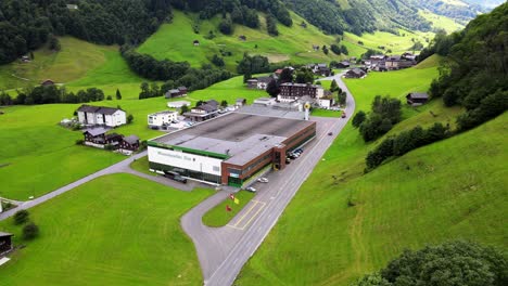 Slow-aerial-shot-flying-towards-mineral-water-plant-in-Elm,-Glarus,-Switzerland