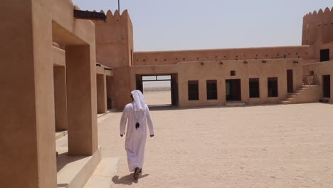 Einheimische-Aus-Katar,-Die-In-Einem-Weißen-Thobe-Und-Gutra-Durch-Die-Festung-Al-Zubara-Gehen
