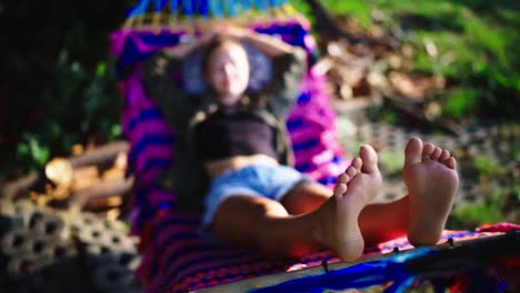 Close-up-of-woman's-feet-while-relaxing-in-a-hammock-outdoors-during-sunset
