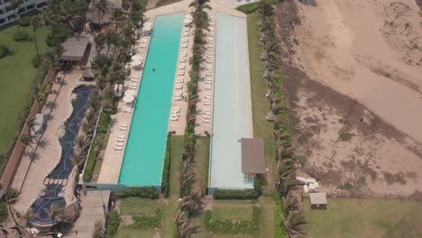 Neigen-Sie-Die-Luftaufnahme-Von-Großen-Pools-Und-Einem-Gehobenen-Luxushotelresort-In-Acapulco,-Mexiko