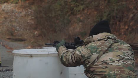 Man-Wearing-Camouflage-and-Gloves-Shooting-an-AR-15-at-Gun-Range