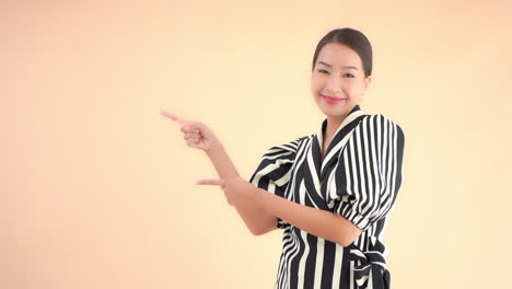 Portrait-of-Young-Asian-Businesswoman-Pointing-With-Fingers-on-Something-on-Left-Static-Full-Frame-Slow-Motion