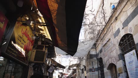 Toma-En-Movimiento,-Mirando-Hacia-Arriba,-Luego-Hacia-Abajo-A-La-Gente-Caminando-Por-El-Bazar-En-Damaskus,-Siria