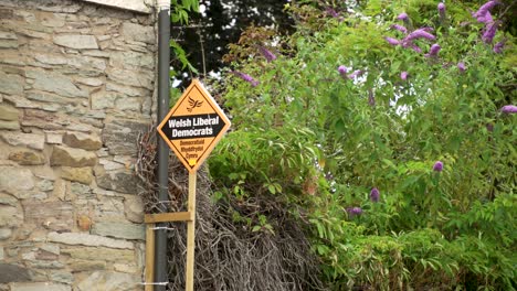 Political-Party-Welsh-Liberal-Democrats-Garden-Poster-for-the-election,-attached-to-brick-house