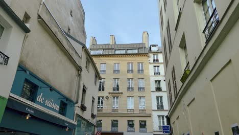 Birds-Flying-Over-The-Quiet-Street-With-Commercial-Buildings-In-Paris,-France