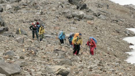 Group-of-mountaineers-climbing-up-Mount-Asahi-Dake-in-Japan,-guided-hiking-tour
