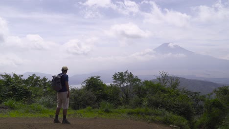 Excursionista-Masculino-Caminando-Hacia-El-Marco-En-La-Cima-De-La-Montaña-Mirando-Hacia-La-Silueta-Del-Monte