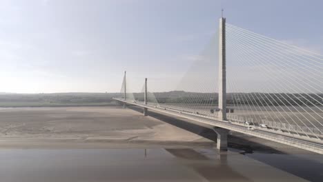 Landmark-Mersey-Gateway-bridge-traffic-crossing-river-Mersey-aerial-dolly-right-view-skyline