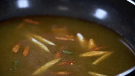 Adding-Chilli-Lemongras-and-Galangal-in-Traditional-Thai-Tom-Yum-Soup