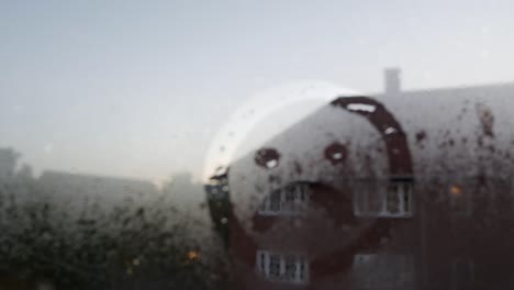 Sad-face-drawn-on-window-glass-with-condensation,-pull-focus