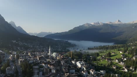 Aerial-of-early-morning-mist-in-a-valley-in-North-italy-in-a-little-town-called-Cortina-d'empezzo