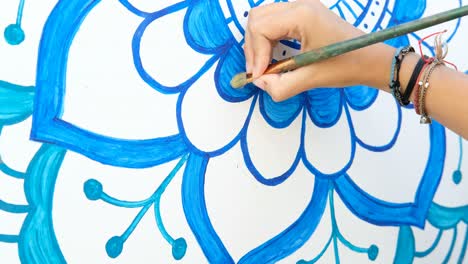 girl-drawing-painting-mandala-on-the-wall