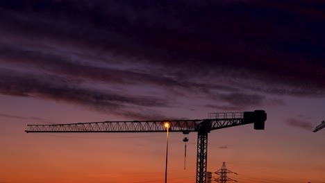 Black-clouds-glide-gently-at-dusk-over-a-construction-crane