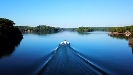 Motor-boat-fast-gliding-on-lake-amongst-hills-and-forest