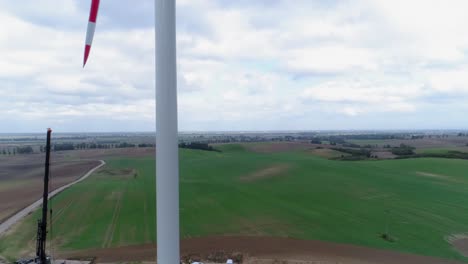 White-Steel-Tower-Windmills-In-A-Wind-Farm-In-Kwidzyn,-Poland---Drone-Panning-Shot