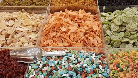 Dried-fruits-and-nuts-store-in-Dubai-Gold-Souk,-very-colorful-and-well-organized-into-square-containers,-slowly-tilting-upwards-video-clip