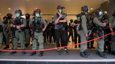 Riot-police-officers-stand-on-guard-and-film-member-of-the-press-and-protesters-near-the-Legislative-Council-building,-known-as-Legco,-in-Admiralty,-Hong-Kong