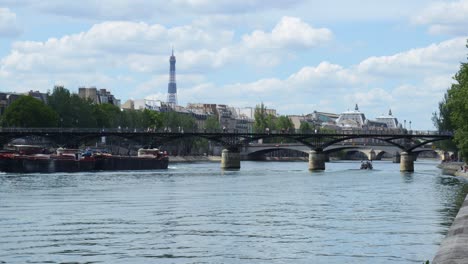 Pont-des-Arts-and-Seine-river-in-Paris-with-people-walking-during-summer-day,-still-establishing-shot-editorial