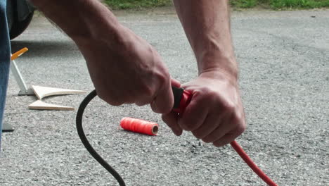 Man-unplugging-power-tool-from-extension-cord-outside,-Close-Up,-Slow-Motion