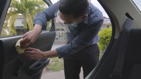 Man-With-Face-Mask-Wiping-Off-And-Disinfecting-His-Car-After-Dropping-Off-His-Passengers-During-COVID-19-Pandemic