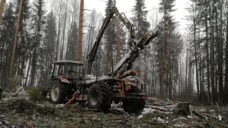 Log-Loader-At-Work-In-A-Winter-Forest-During-Snowstorm---full-shot