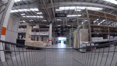 Inside-DIY-home-improvement-shopping-cart-pushing-trolley-down-storage-aisle-as-customers-shop-during-corona-virus-pandemic