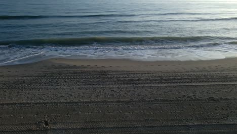 Tilt-down-static-shot-of-ocean-waves-at-the-beach